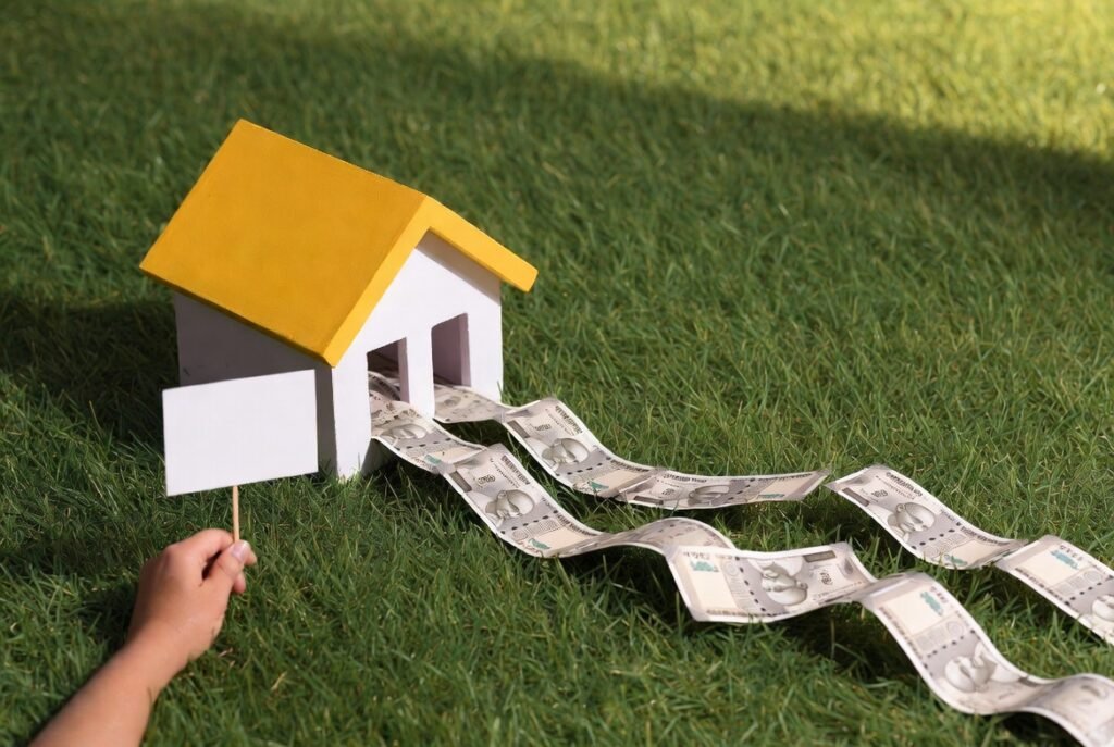 Model house with currency flowing out, representing real land price near Tambaram in 2026 and property value growth