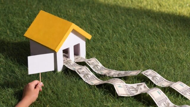 Model house with currency flowing out, representing real land price near Tambaram in 2026 and property value growth