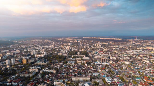 "Aerial drone view of a lush green gated community in Chennai featuring premium villa plots with wide internal roads, landscaped parks, and modern clubhouse facilities."