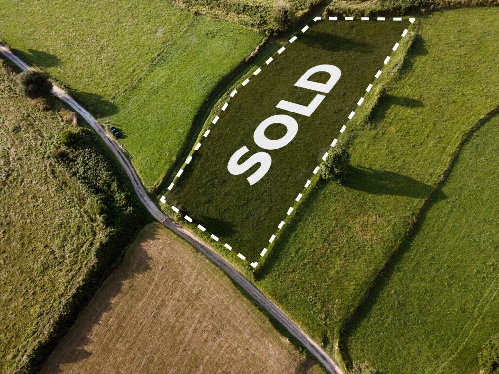 "A scenic aerial view of a sprawling one-acre land parcel in India, showing clear boundary markers and proximity to a developing highway, representing a strategic real estate investment."